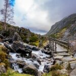 Swallow Falls in Snowdonia Wales, a rushing waterfall with a brudge and track leading into a rugged mountain Landscape