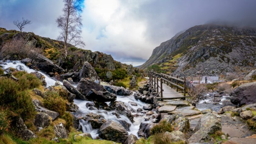 Swallow Falls in Snowdonia Wales, a rushing waterfall with a brudge and track leading into a rugged mountain Landscape