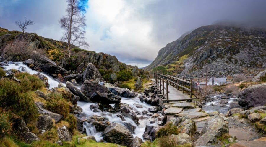 Swallow Falls in Snowdonia Wales, a rushing waterfall with a brudge and track leading into a rugged mountain Landscape