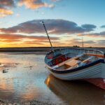 Stunning sunset over a fishing boat at Burnham Overy Staithe on the Norfolk Coast