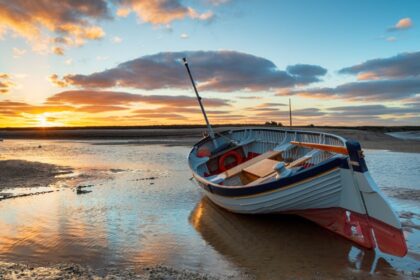 Stunning sunset over a fishing boat at Burnham Overy Staithe on the Norfolk Coast