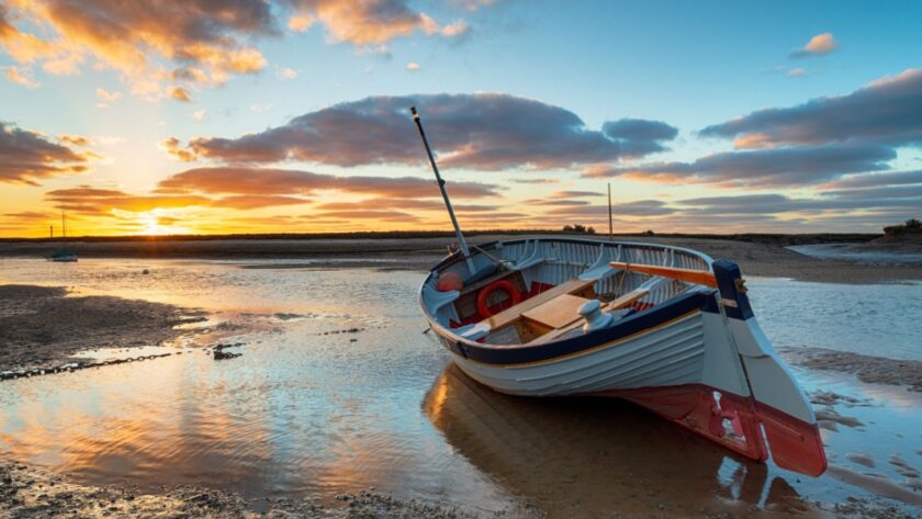 Stunning sunset over a fishing boat at Burnham Overy Staithe on the Norfolk Coast