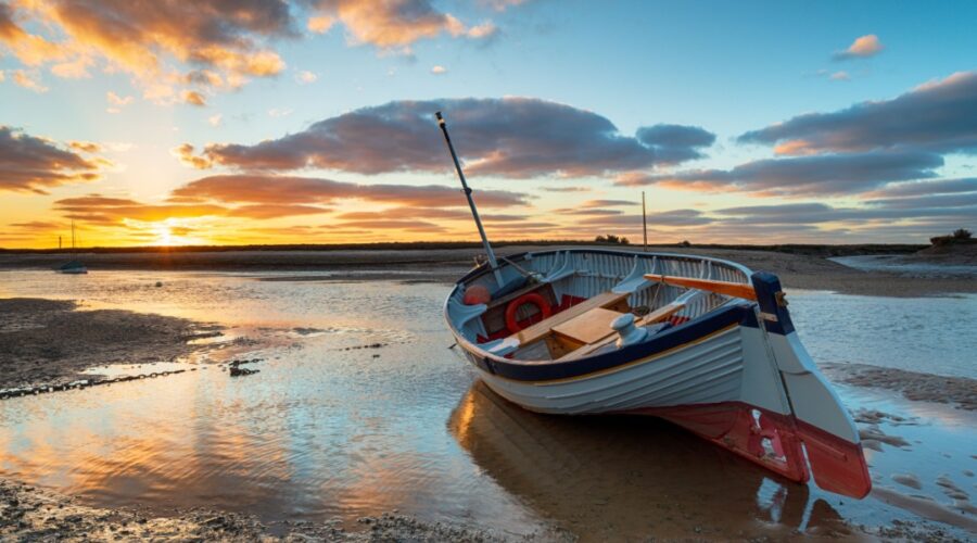 Stunning sunset over a fishing boat at Burnham Overy Staithe on the Norfolk Coast
