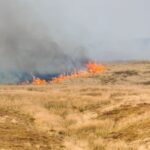 smoke rising from a grass fire burning uncontrolled on a Pennine moor