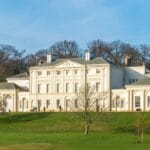 Kenwood House, a grand 18th-century stately home with white neoclassical façade, set in green parkland on Hampstead Heath in London