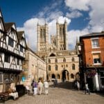 View of Lincoln Cathedral with historic half-timbered houses and red-brick buildings on Steep Hill, Lincoln, England