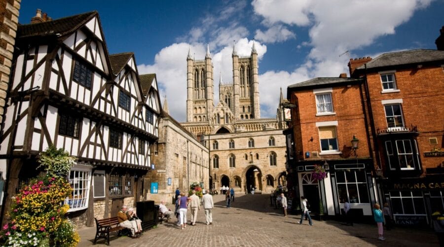 View of Lincoln Cathedral with historic half-timbered houses and red-brick buildings on Steep Hill, Lincoln, England