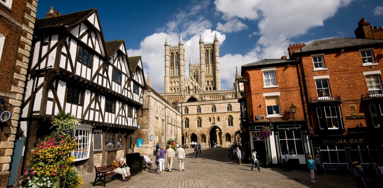View of Lincoln Cathedral with historic half-timbered houses and red-brick buildings on Steep Hill, Lincoln, England
